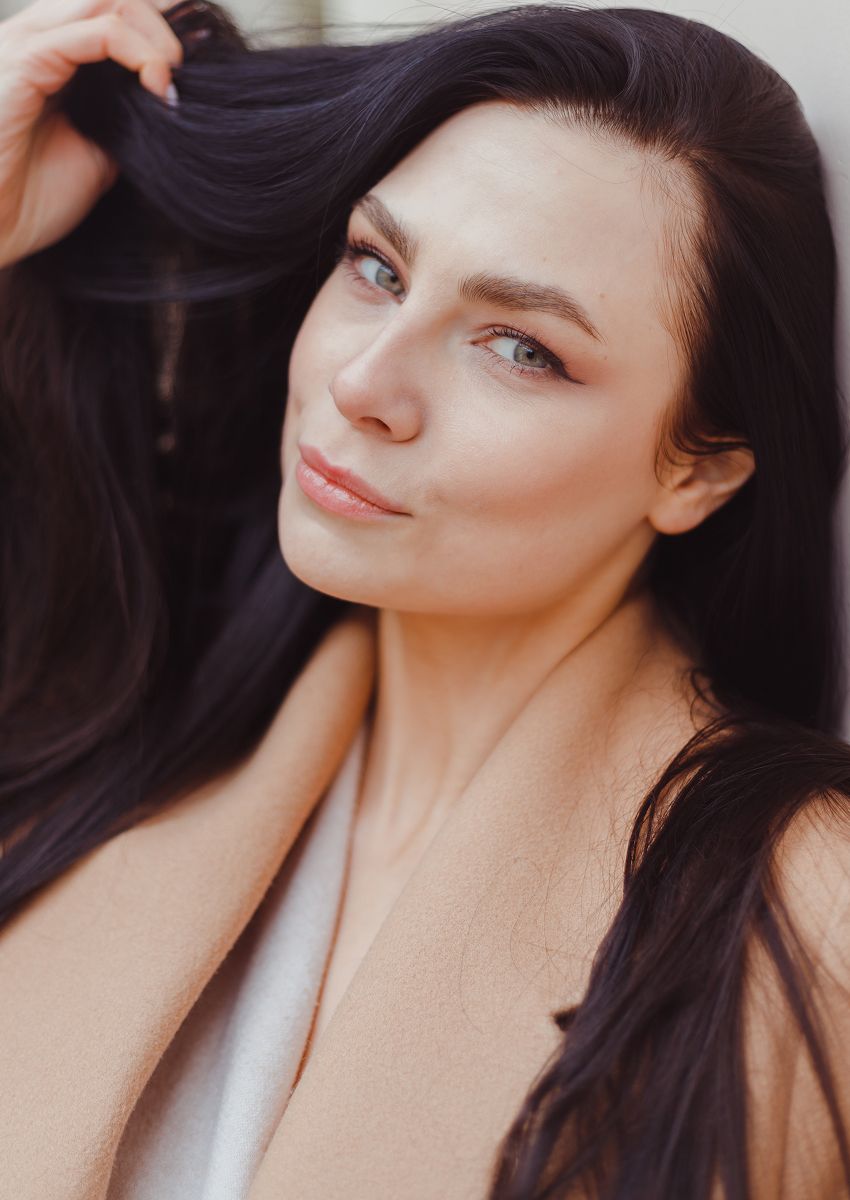 Woman with blonde hair and statement jewelry.