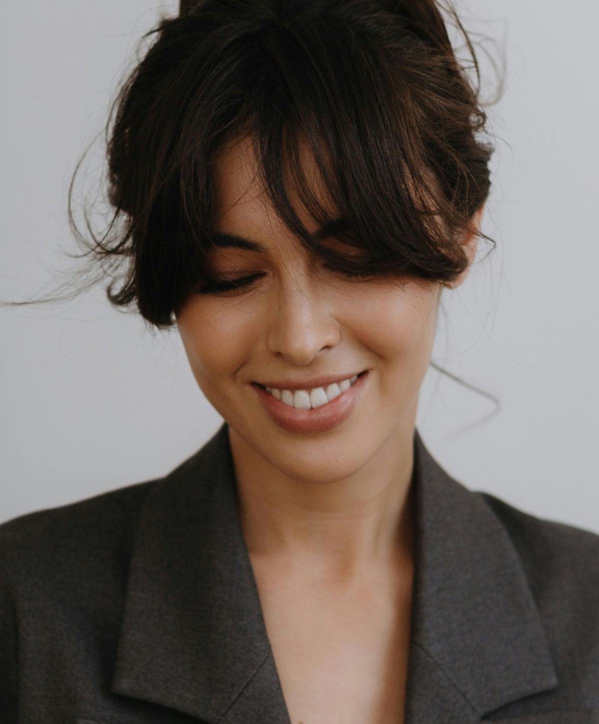 Smiling woman with stylish hair, soft expression.