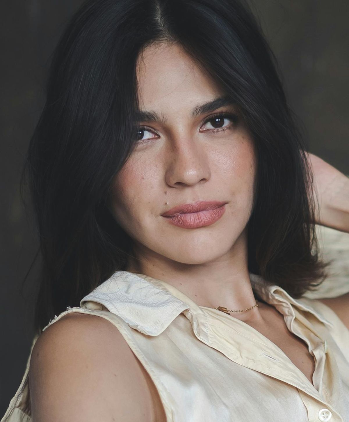 Woman with long hair looking back over shoulder.