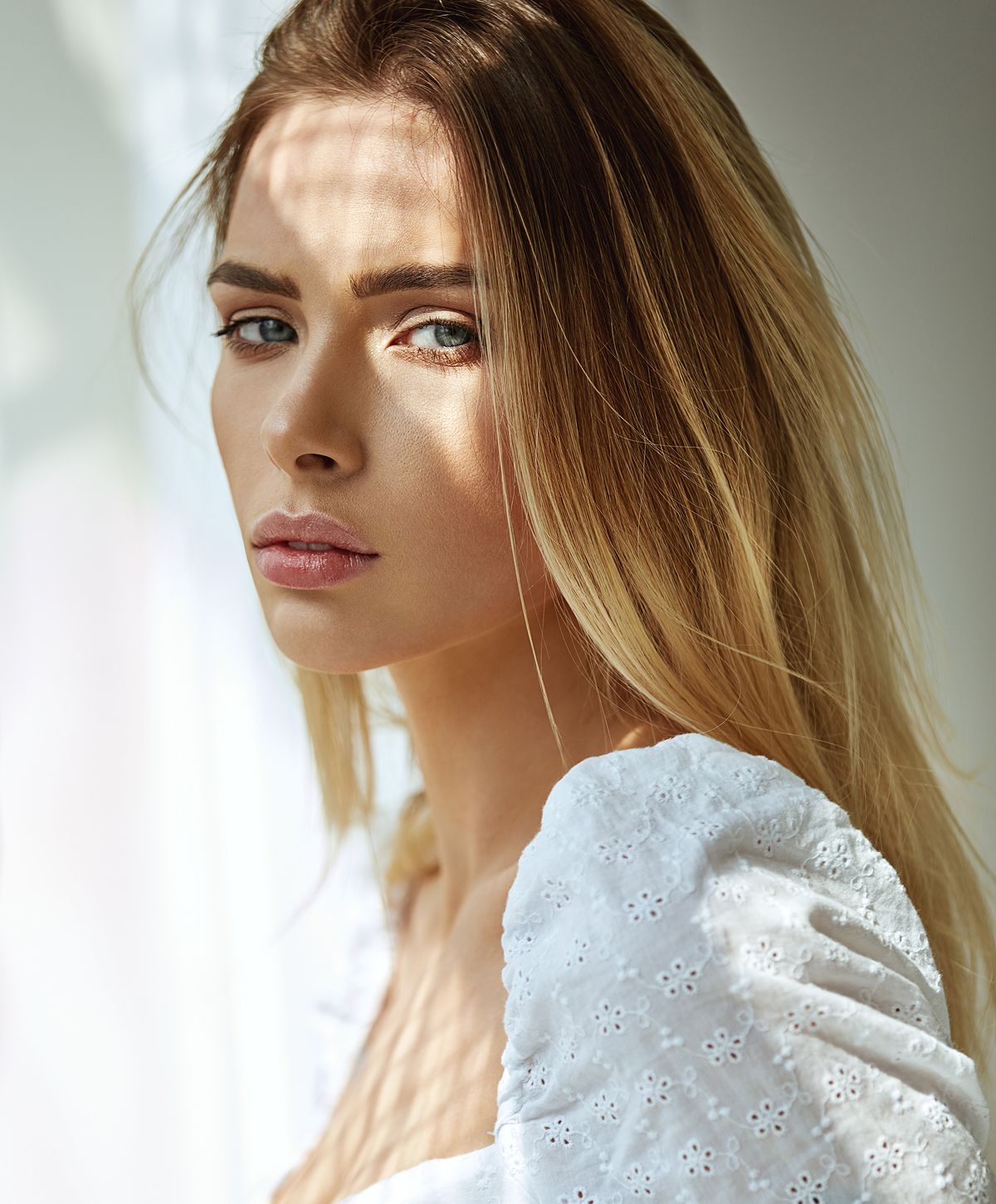 Woman with long hair in soft lighting.