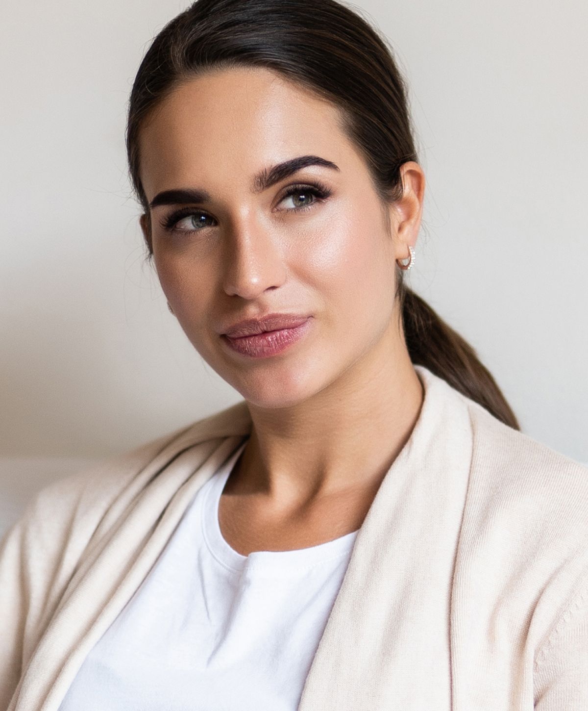 Woman in casual attire, looking thoughtfully away.