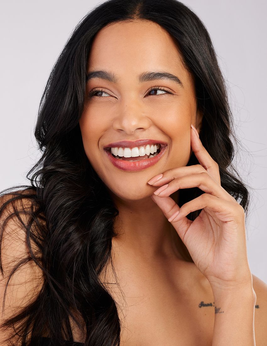 Woman in activewear posing outdoors near water.