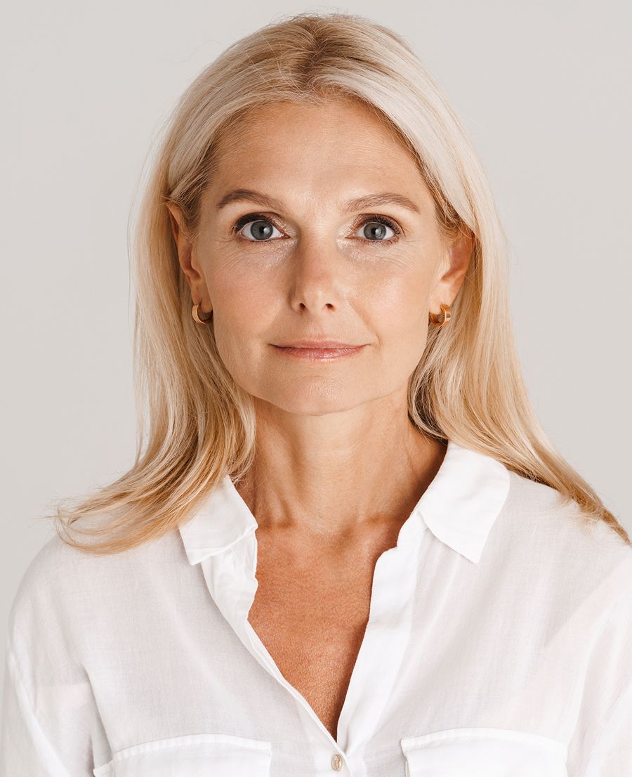 Woman with long hair, neutral makeup expression.