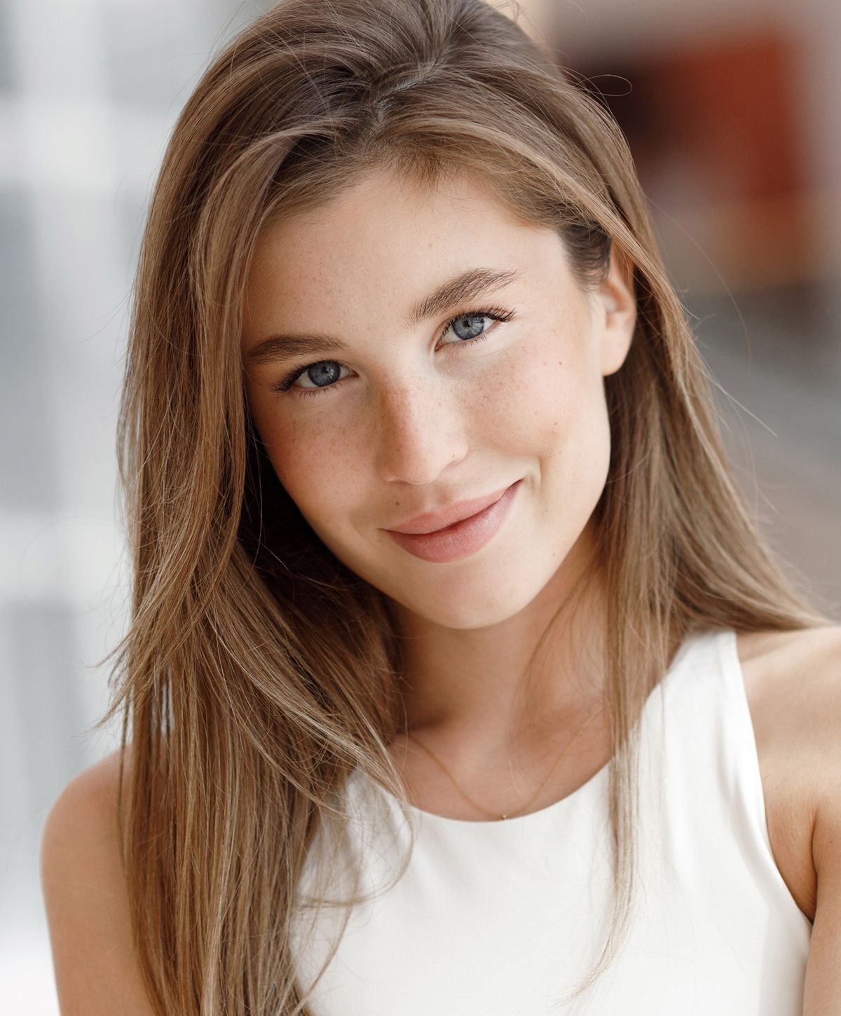 Young woman with long hair and bright smile.