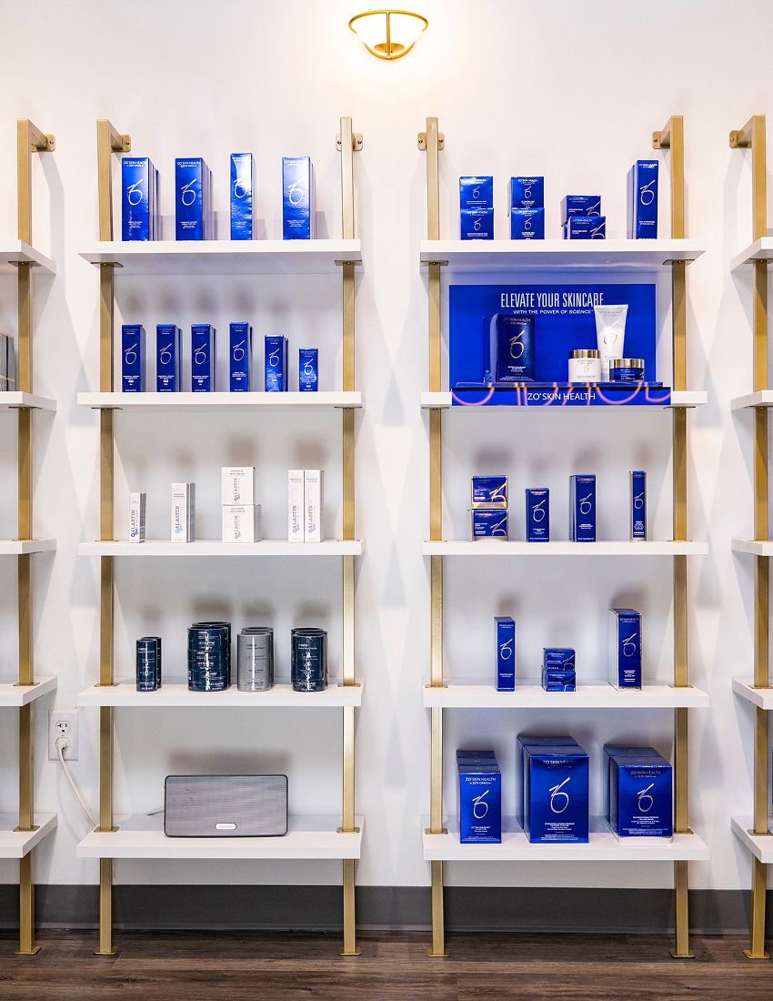 Skincare products displayed on white shelves.