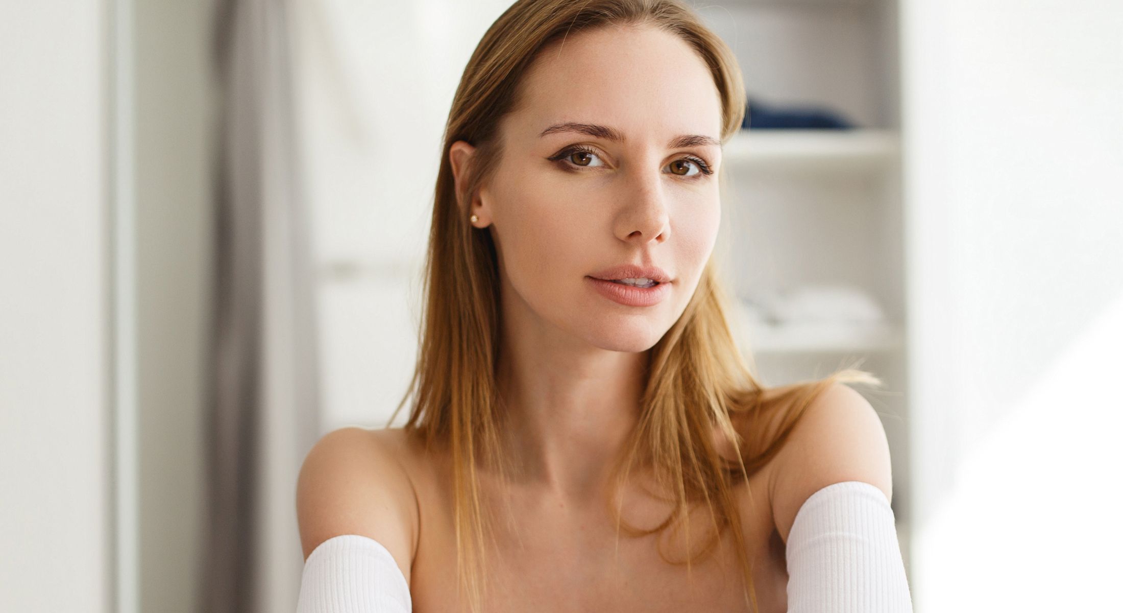 Woman with long hair in soft lighting.